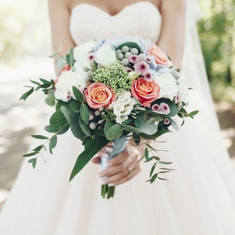 caucasian bride holding bouquet of flowers outdoors royalty free image